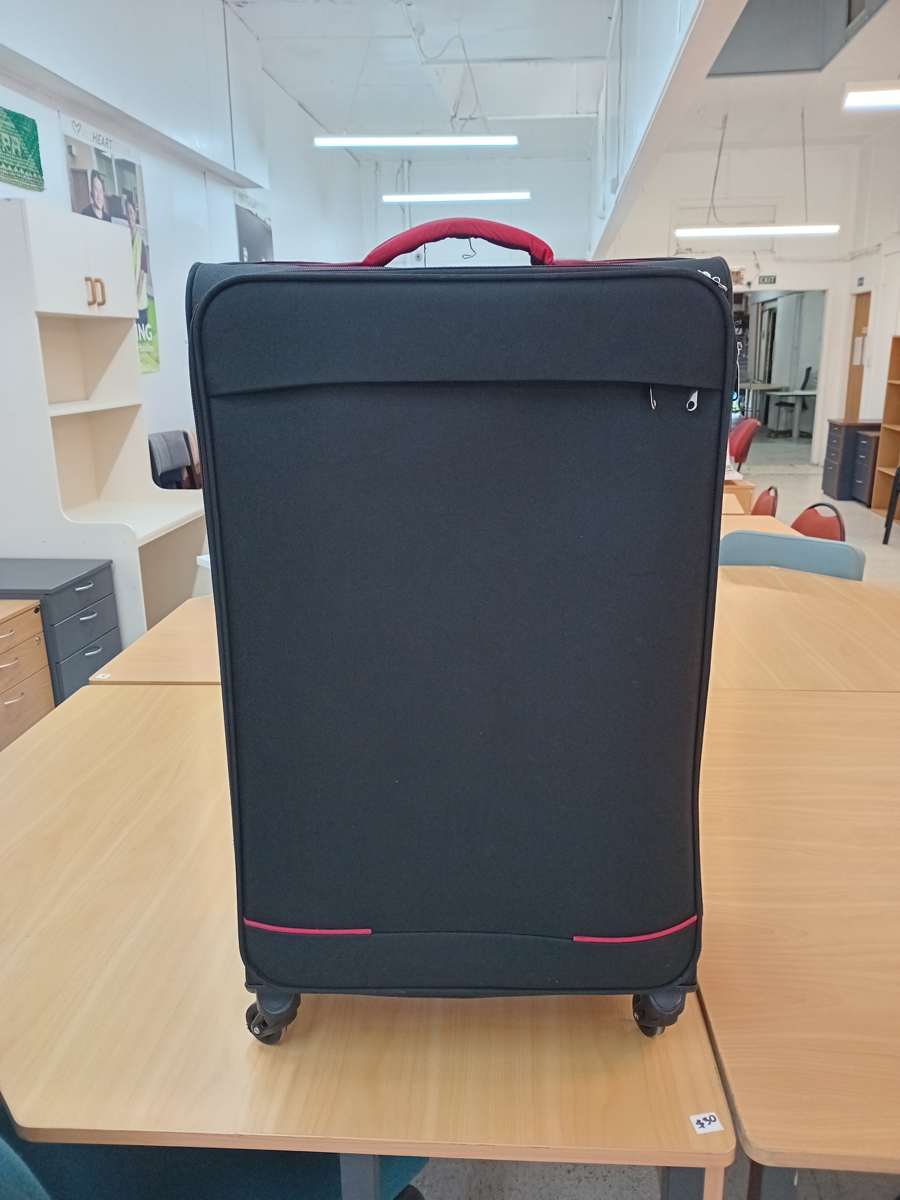 Large black suitcase with red trim